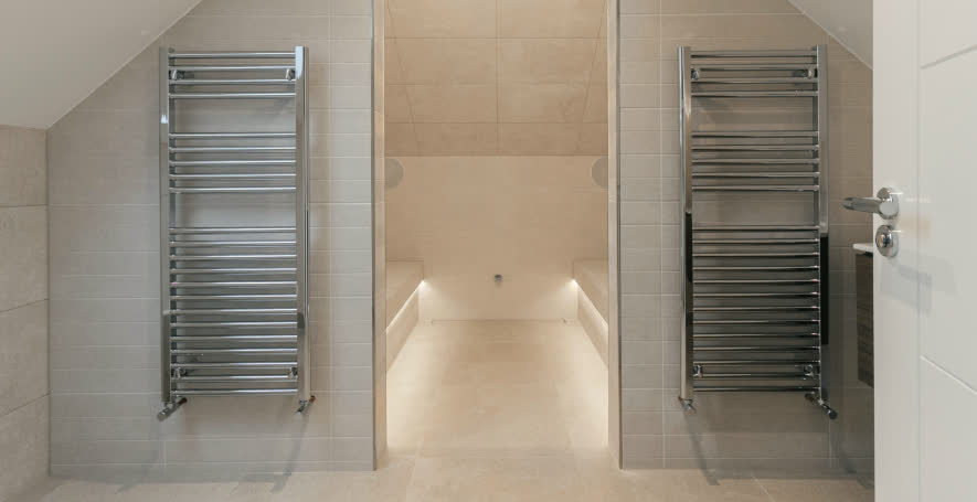 Chrome heated towel rails fitted either side of a wet room doorway
