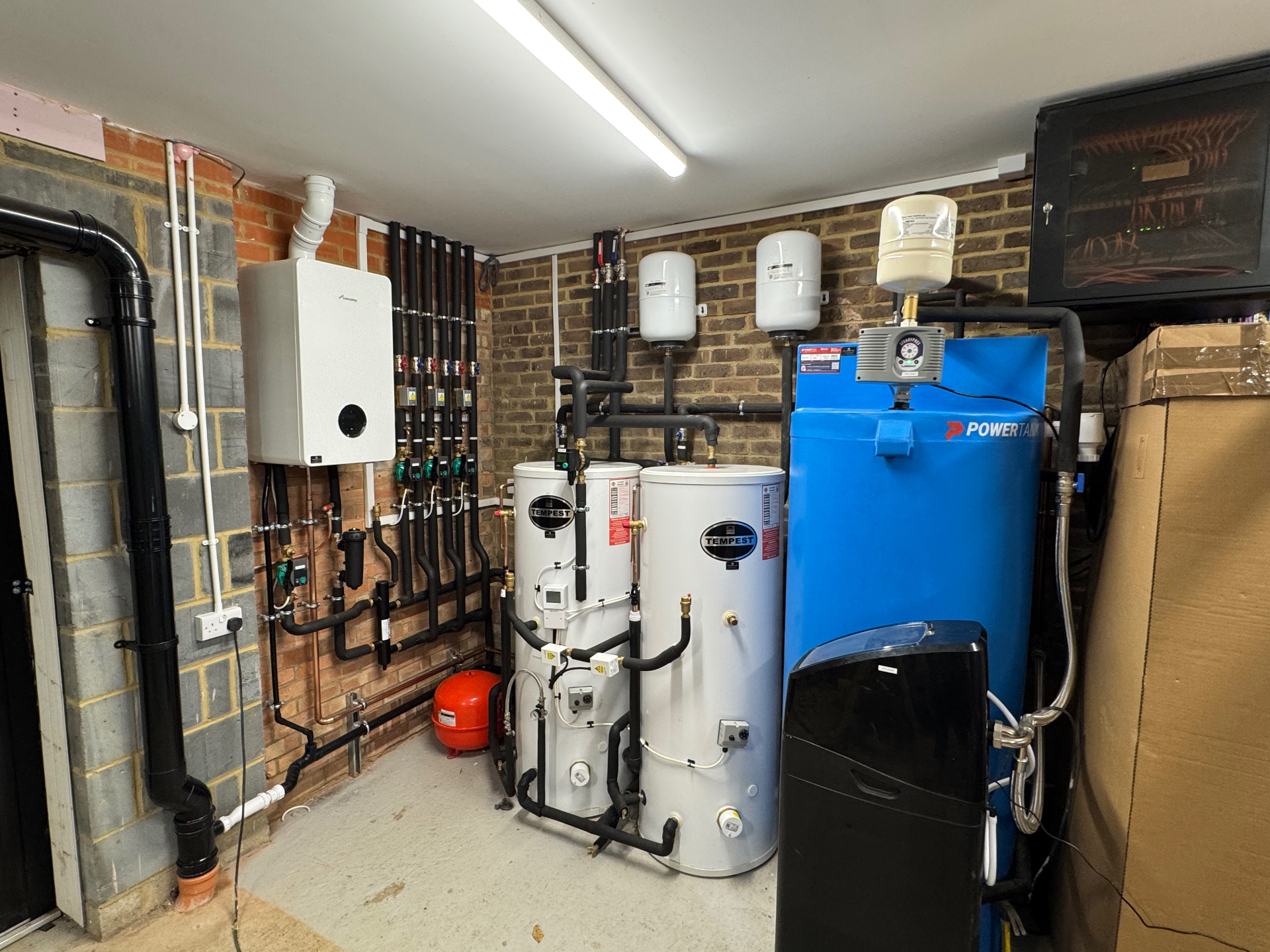 Plant room fitted with unvented hot-water cylinders, expansion vessels and a system boiler